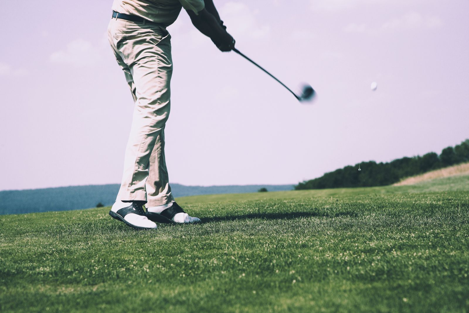 Golfer mid-swing on the fairway